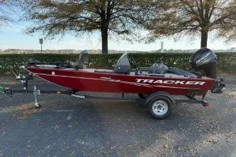 Slide: The Image of 2020 Tracker Pro 160 boat in red, parked on a trailer outdoors. - 6