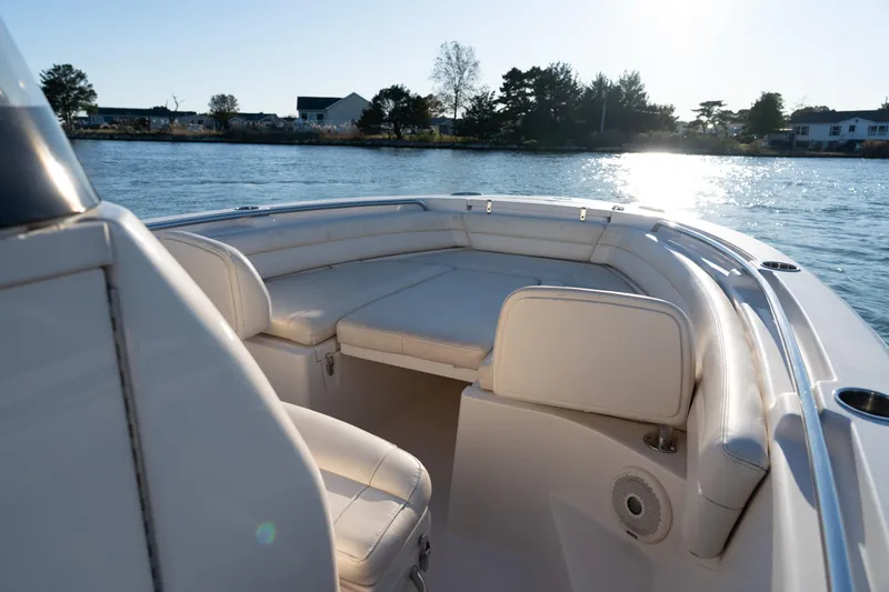 Slide: The Image of 2018 Grady-White Fisherman 236 boat interior with cushioned seating on a sunny day. - 4