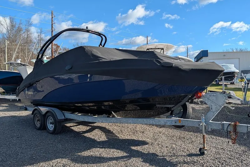 Slide: The Image of 2017 Yamaha 242 Limited S boat covered on a trailer, parked outdoors. - 1