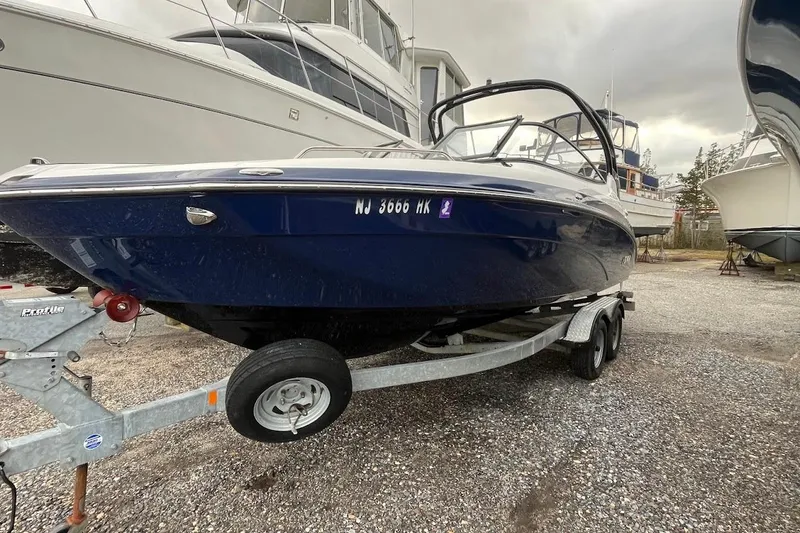 Slide: The Image of 2017 Yamaha 242 Limited S boat on trailer, parked in a marina. - 2