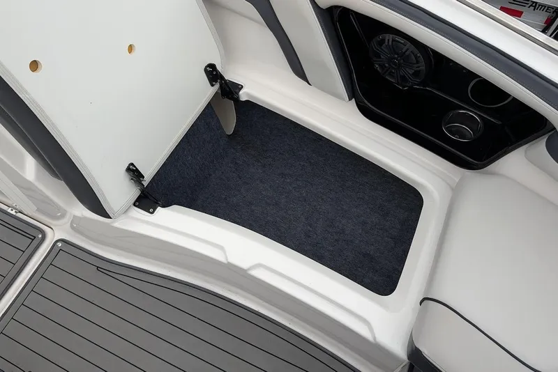 Slide: The Image of 2017 Yamaha 242 Limited S boat storage compartment with open lid and carpeted interior. - 22