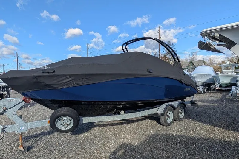 Slide: The Image of 2017 Yamaha 242 Limited S boat covered on a trailer, parked outdoors. - 26