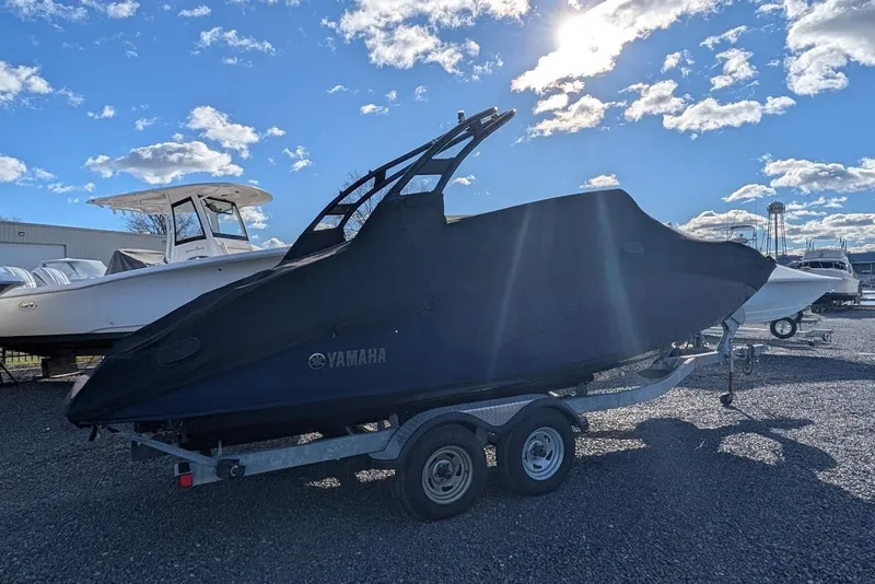 Slide: The Image of 2017 Yamaha 242 Limited S boat covered on trailer under blue sky. - 28