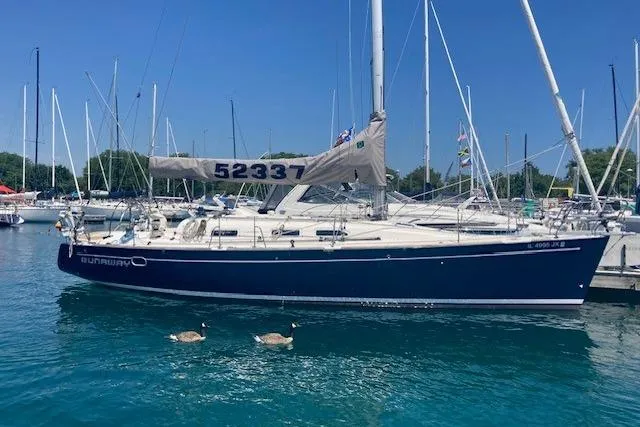 The Image of 2005 Elan 40 sailboat docked in marina, with two ducks swimming nearby. - 1