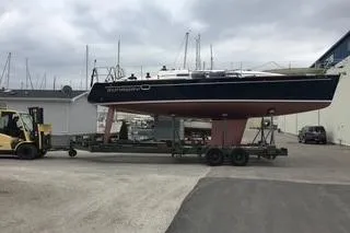 Slide: The Image of 2005 Elan 40 sailboat on trailer, transported by forklift in marina setting. - 10