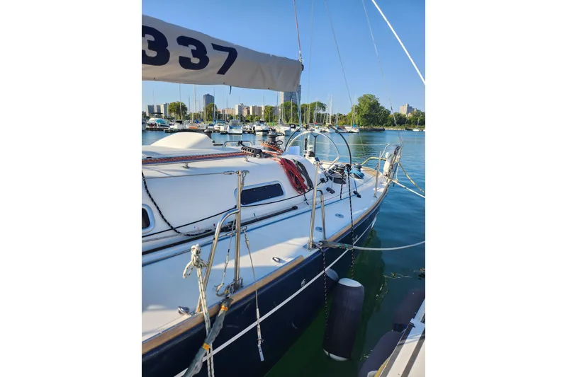 Slide: The Image of 2005 Elan 40 sailboat docked in a marina with cityscape background. - 11