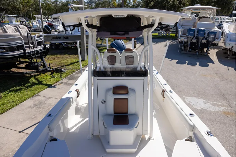 Slide: The Image of 2018 Ranger 2510 Bay Ranger boat interior with seating and console, docked outdoors. - 17