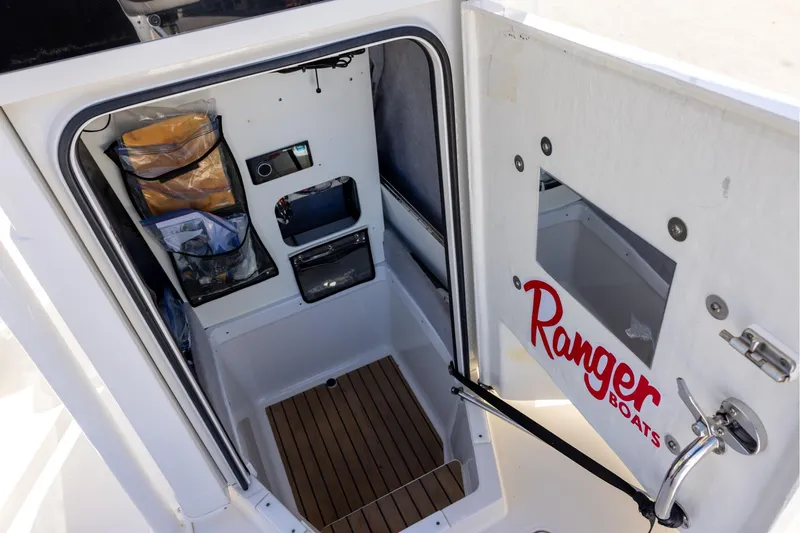 Slide: The Image of 2018 Ranger 2510 Bay Ranger boat interior with storage and wooden flooring. - 18