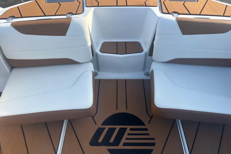 Slide: The Image of 2025 Malibu Response TXi boat interior with white and brown seating and logo on floor. - 14