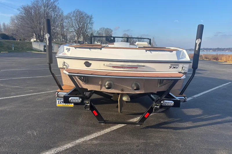 Slide: The Image of 2025 Malibu Response TXi boat on trailer in parking lot, rear view. - 4