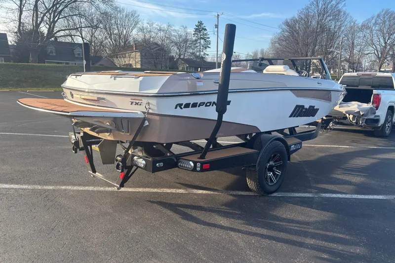 Slide: The Image of 2025 Malibu Response TXi boat on trailer in parking lot, sunny day. - 5