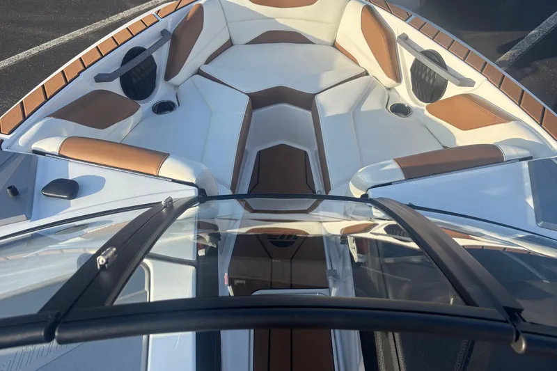Slide: The Image of 2025 Malibu Response TXi boat interior with white and brown seating, cup holders, and sleek design. - 7