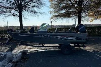 Slide: The Image of 2007 Lund 1775 Classic Sport boat on trailer, parked outdoors with trees in background. - 5