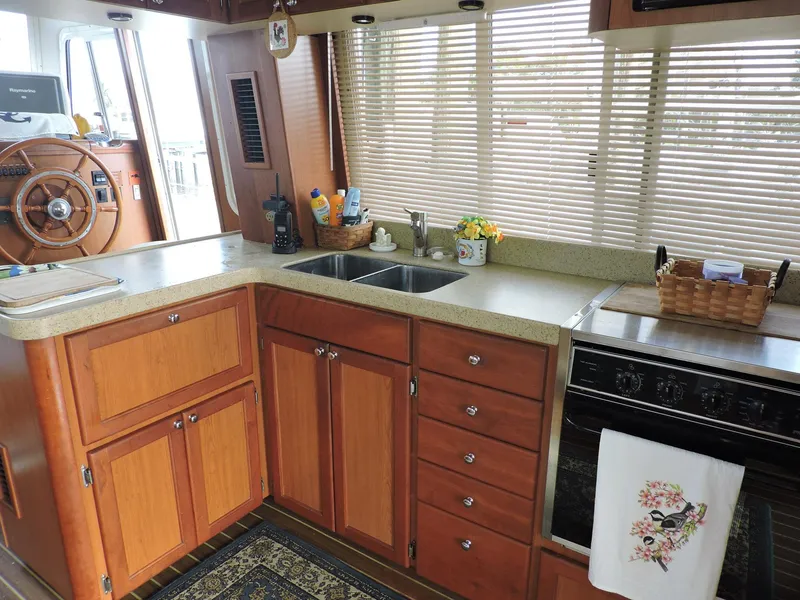 Slide: The Image of 2007 Mainship 400 Trawler kitchen with wooden cabinets, dual sink, and stove. - 6