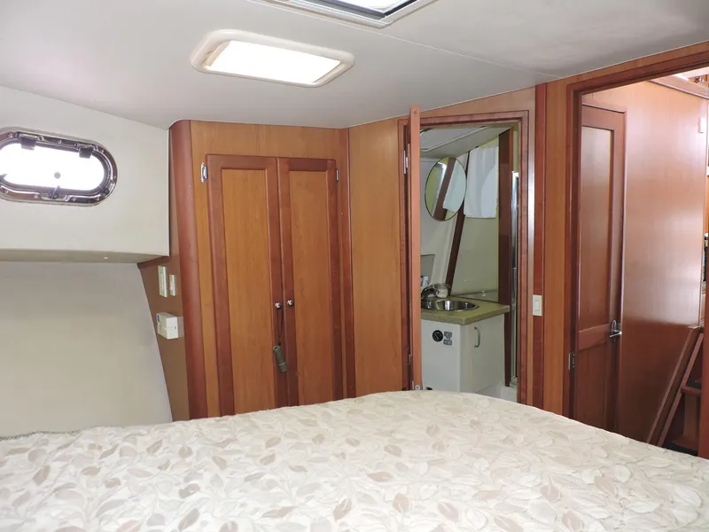Slide: The Image of Interior of 2007 Mainship 400 Trawler, featuring wood cabinetry and a compact bathroom. - 9