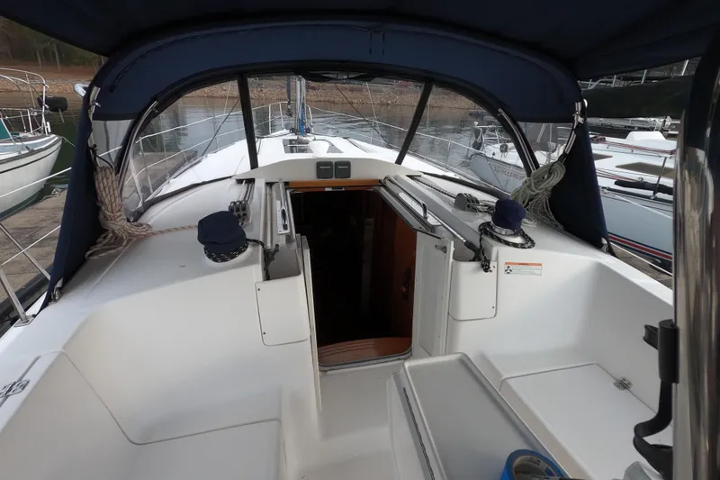 Slide: The Image of Cockpit view of 2013 Marlow-Hunter e33 sailboat with blue canopy and open cabin entrance. - 11