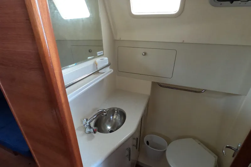 Slide: The Image of 2013 Marlow-Hunter e33 yacht bathroom with sink, toilet, and storage cabinet. - 23