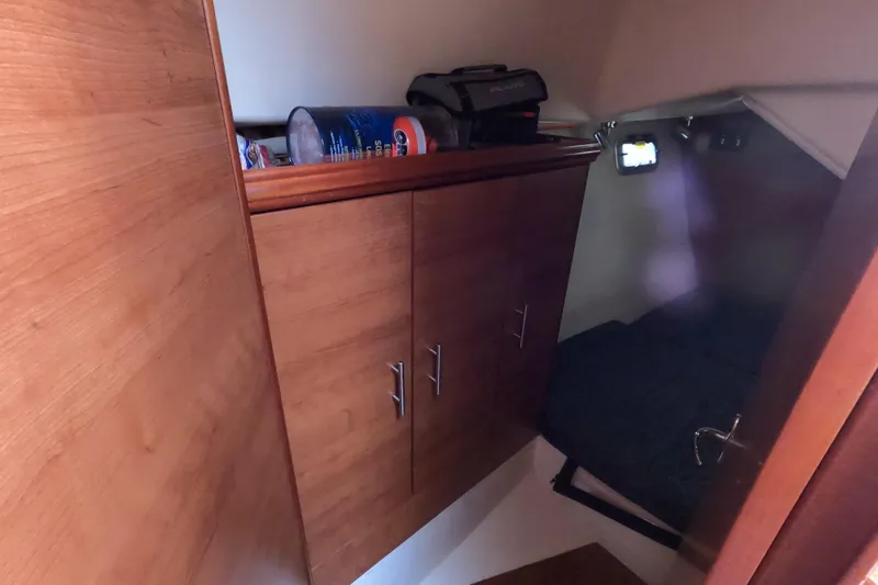 Slide: The Image of 2013 Marlow-Hunter e33 cabin interior with wooden cabinets and cozy sleeping area. - 24