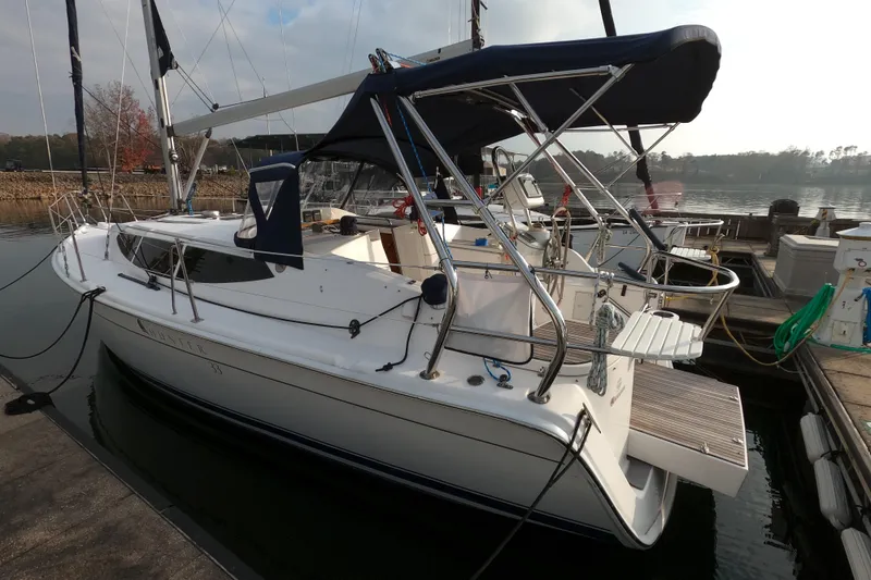 Slide: The Image of 2013 Marlow-Hunter e33 sailboat docked at a marina, featuring sleek design and canopy. - 3