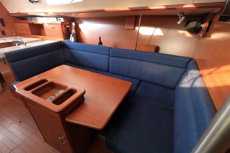 Slide: The Image of 2013 Marlow-Hunter e33 yacht interior with blue cushioned seating and wooden table. - 36