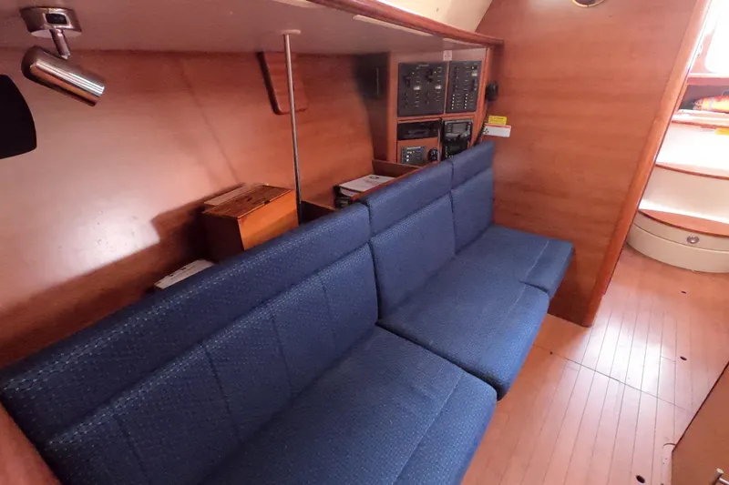 Slide: The Image of Interior of 2013 Marlow-Hunter e33 sailboat with blue seating and wooden paneling. - 38