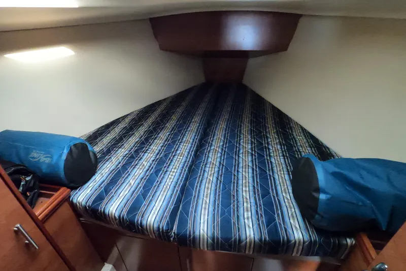 Slide: The Image of 2013 Marlow-Hunter e33 cabin interior with striped bedding and storage compartments. - 40