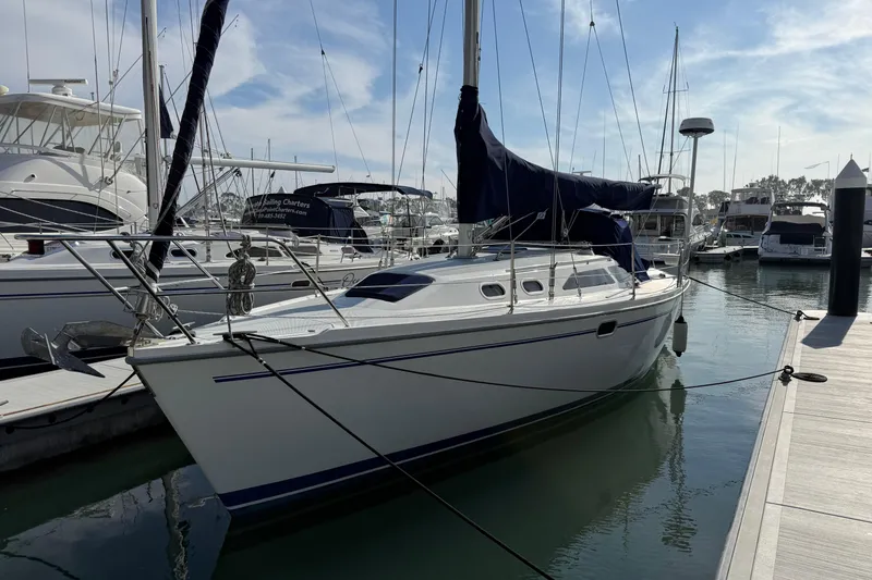 Slide: The Image of Catalina 320 sailboat from 2000 docked in a marina under a clear sky. - 0