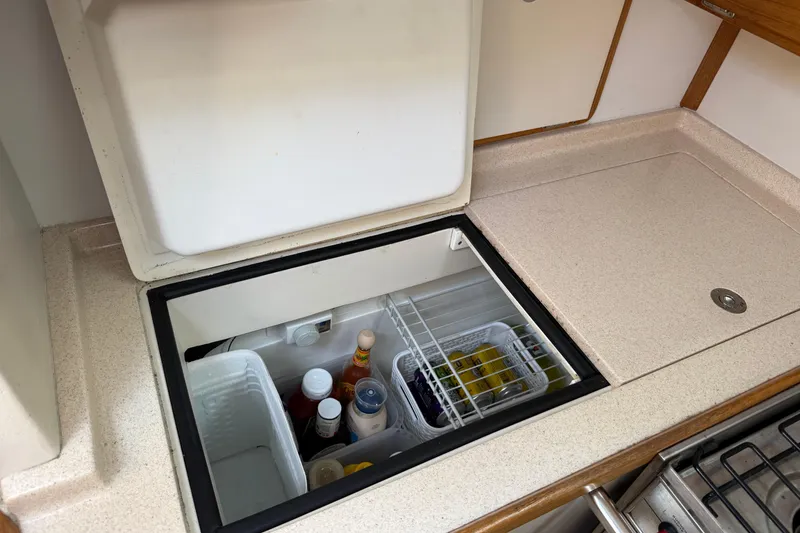 Slide: The Image of Built-in refrigerator in 2000 Catalina 320 yacht kitchen, stocked with condiments and beverages. - 12