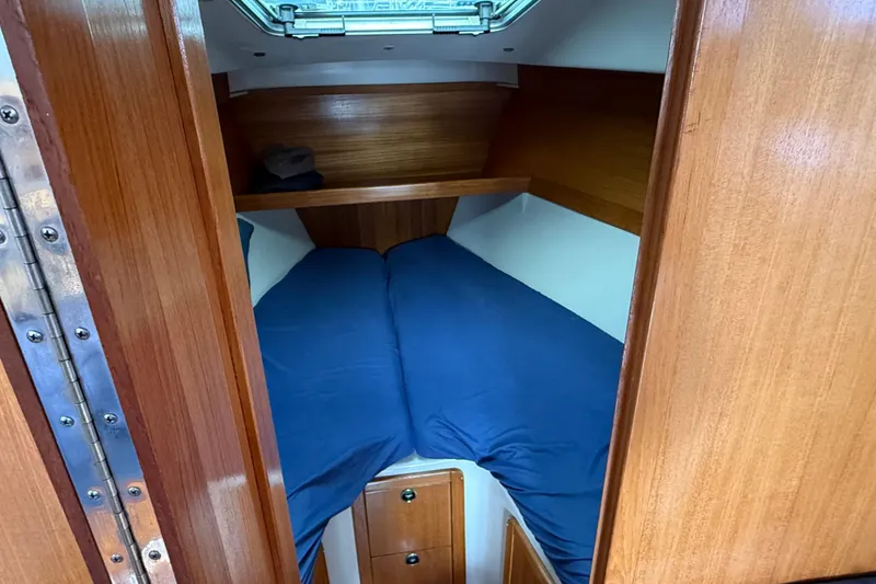 Slide: The Image of Cozy cabin interior of 2000 Catalina 320 sailboat with blue bedding. - 13