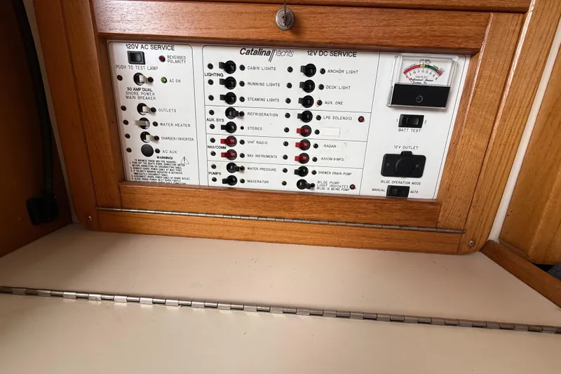 Slide: The Image of Electrical control panel of a 2000 Catalina 320 yacht, featuring AC and DC service switches. - 15