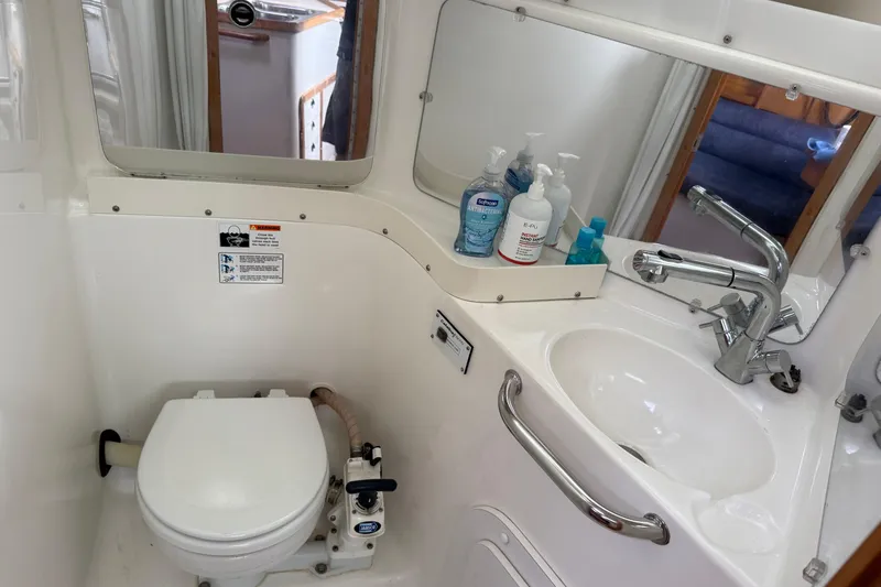 Slide: The Image of Bathroom in a 2000 Catalina 320 yacht with sink, toilet, and toiletries. - 18