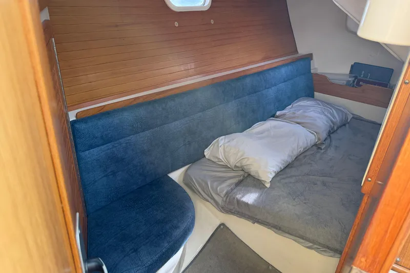 Slide: The Image of Cozy cabin interior of 2000 Catalina 320 sailboat with blue seating and bed. - 19
