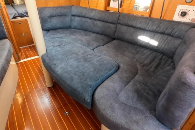 Slide: The Image of Cozy interior of a 2000 Catalina 320 sailboat with plush blue seating. - 22