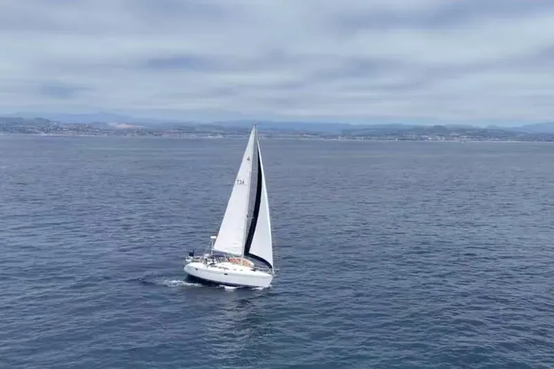 Slide: The Image of Sailboat Catalina 320 (2000) cruising on open sea under cloudy sky. - 26