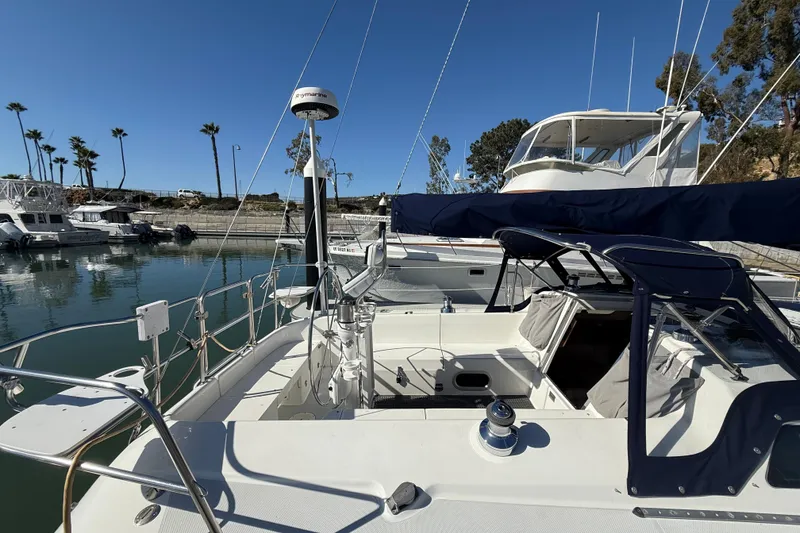 Slide: The Image of 2000 Catalina 320 sailboat docked in marina, clear sky, palm trees in background. - 5