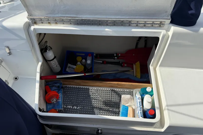 Slide: The Image of Open storage compartment on 2000 Catalina 320 sailboat with cleaning supplies and tools. - 8