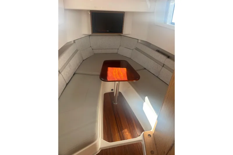 Slide: The Image of 2021 Pursuit S 378 Sport cabin interior with cushioned seating and wooden table. - 17