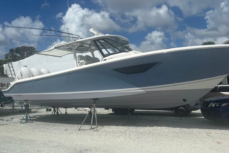 Slide: The Image of 2021 Pursuit S 378 Sport boat on stands under a cloudy sky. - 18