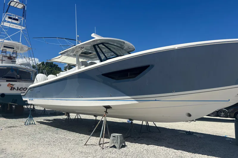 Slide: The Image of 2021 Pursuit S 378 Sport boat on stands under clear blue sky. - 19