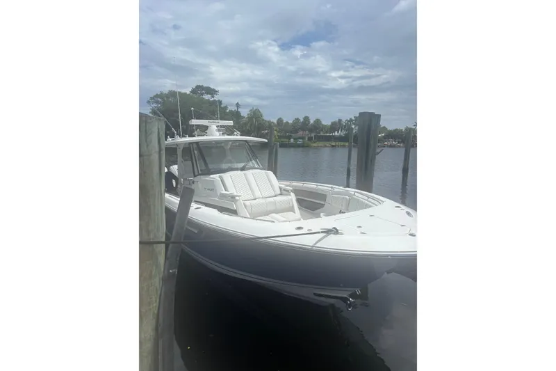 Slide: The Image of 2021 Pursuit S 378 Sport boat docked on a calm river under cloudy skies. - 4