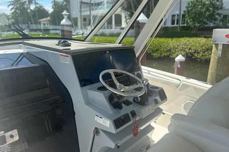 Slide: The Image of 2021 Pursuit S 378 Sport boat helm with steering wheel and controls. - 9