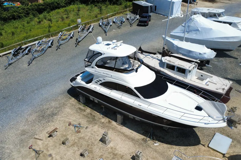 Slide: The Image of 2007 Sea Ray 52 Sedan Bridge yacht on dry dock with trailers nearby. - 0