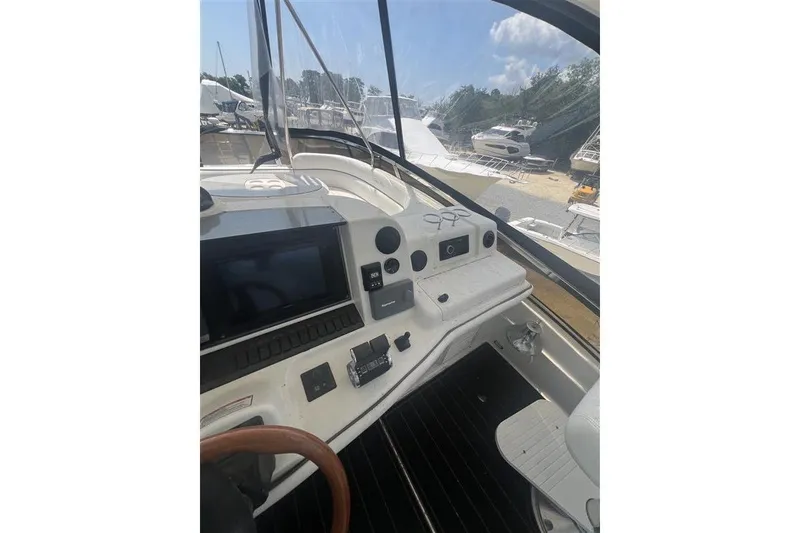 Slide: The Image of 2007 Sea Ray 52 Sedan Bridge helm with navigation controls and steering wheel. - 10