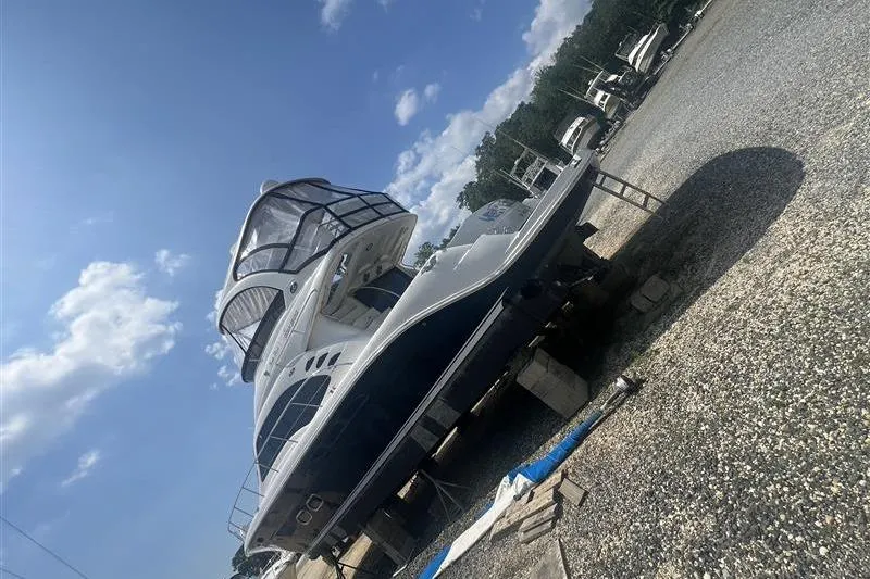 Slide: The Image of 2007 Sea Ray 52 Sedan Bridge yacht on dry dock under a clear blue sky. - 12