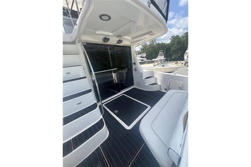 Slide: The Image of 2007 Sea Ray 52 Sedan Bridge yacht deck with seating and stairs, featuring sleek design. - 2