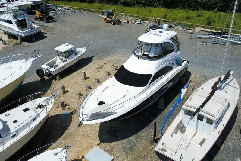 Slide: The Image of 2007 Sea Ray 52 Sedan Bridge yacht in a boatyard, surrounded by other vessels. - 29