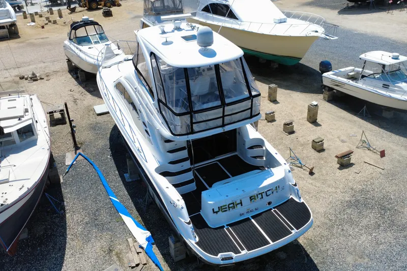Slide: The Image of 2007 Sea Ray 52 Sedan Bridge yacht in a boatyard, surrounded by other vessels. - 30