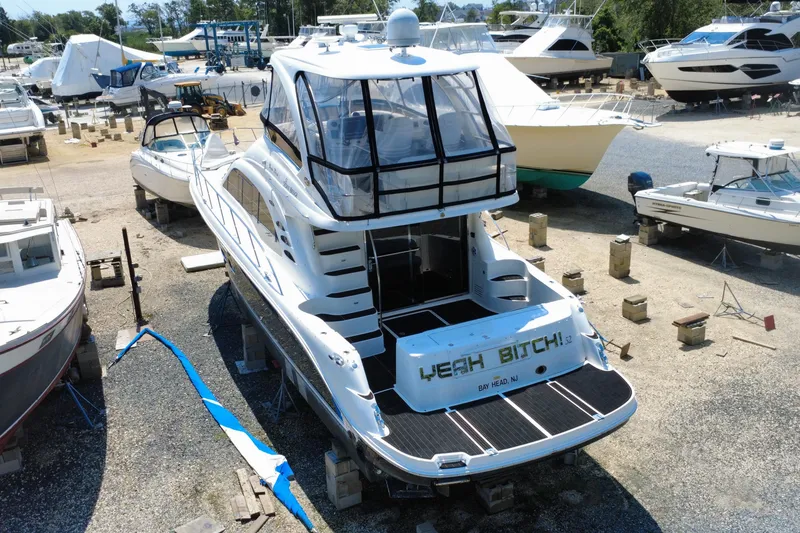 Slide: The Image of 2007 Sea Ray 52 Sedan Bridge yacht in a boatyard, surrounded by other vessels. - 31