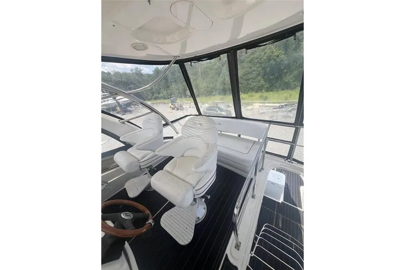 Slide: The Image of 2007 Sea Ray 52 Sedan Bridge interior with white captain's chairs and panoramic windows. - 34