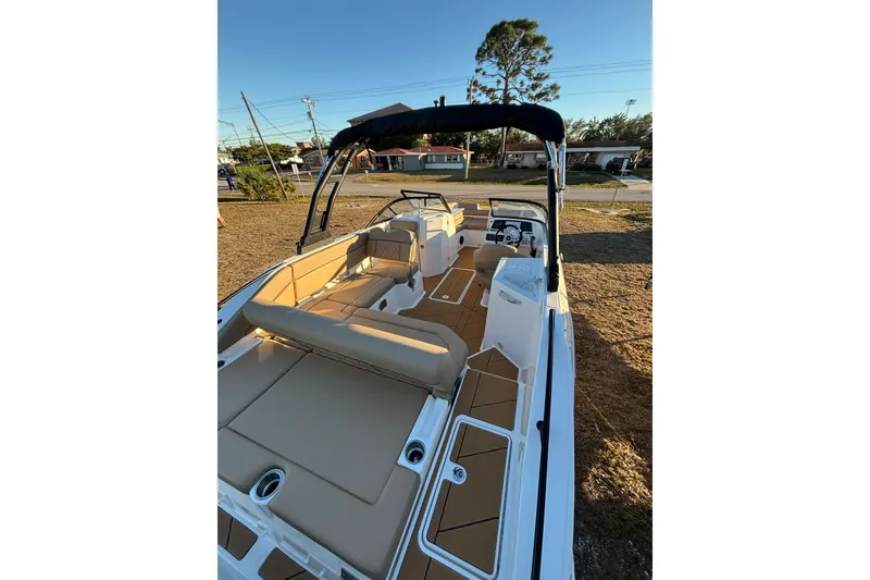 Slide: The Image of 2026 Bayliner D22 boat with tan seating and sleek design, parked outdoors. - 14